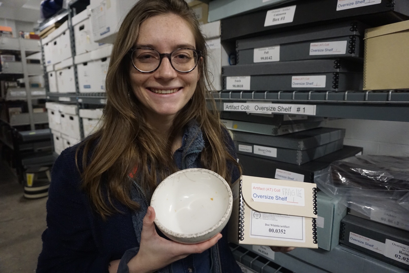 Gillian, holding her favorite artifact at the Institute on World War II and the Human Experience, which comes from the collection that inspired her thesis topic. It is a porcelain bowl used by Dot Douglas’s family throughout their internment, and the only artifact related to Baguio internment at the Institute. 